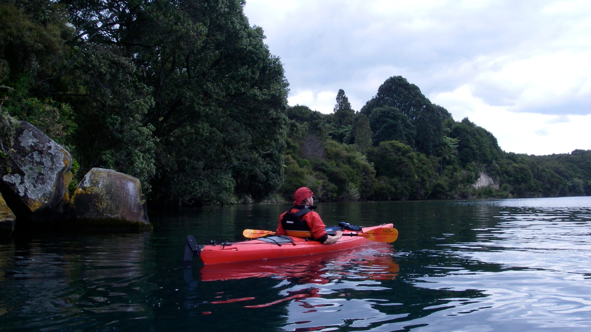 a man riding on the back of a boat in a body of water