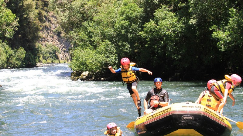 a group of people riding on the back of a boat in the water